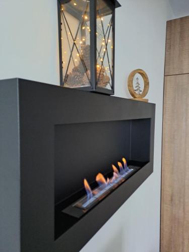 a black fireplace with a fire in it at Large studio with view in Borovets Gardens in Borovets