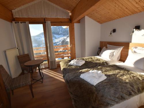 une chambre d'hôtel avec deux lits, une table et des chaises dans l'établissement Chalet spacieux, skis aux pieds avec sauna, jacuzzi et salle de sport, proche centre et pistes - FR-1-467-68, au Grand-Bornand