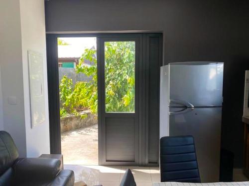 cocina con nevera y puerta con ventana en Maison de 2 chambres avec vue sur la ville jardin clos et wifi a Saint Louis a 8 km de la plage, en Saint-Louis