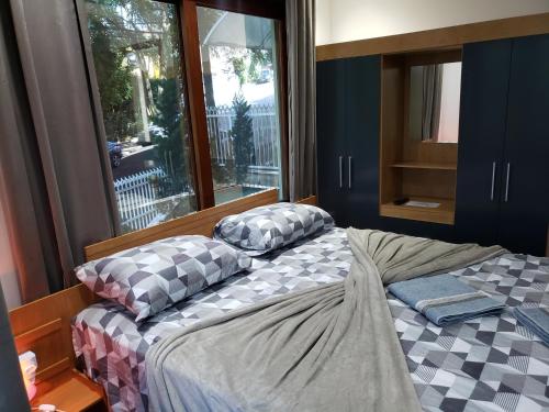 a bedroom with two beds with pillows and a window at Pousada Monte Sião in Sao Paulo