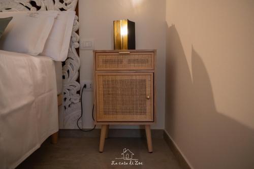 a bedroom with a night stand next to a bed at LA CASA DI ZOE in Manfredonia