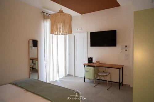 a bedroom with a desk and a television on the wall at LA CASA DI ZOE in Manfredonia