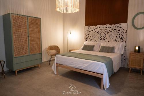 a bedroom with a large bed and a chandelier at LA CASA DI ZOE in Manfredonia
