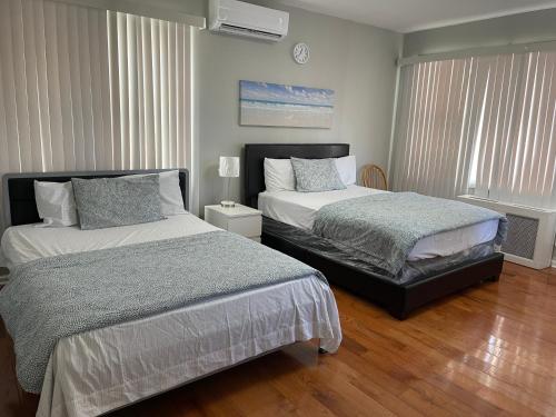 1 Schlafzimmer mit 2 Betten und einem Fenster in der Unterkunft Large 1 Bedroom Apartment in the heart of the Bronx in Unionport