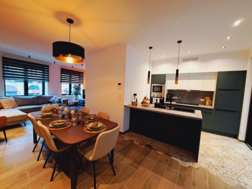 cocina y sala de estar con mesa y sillas en Un gîte sous roche, en La-Roche-en-Ardenne