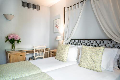 - une chambre avec un lit blanc à baldaquin dans l'établissement Villa Alessandra, à Paris