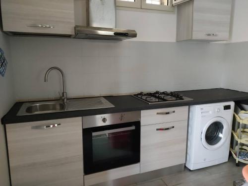La cuisine est équipée d'un évier, d'une cuisinière et d'un lave-vaisselle. dans l'établissement Villa Sole, à Maruggio