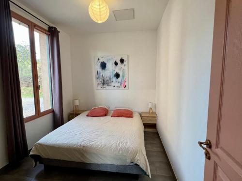 a bedroom with a bed with two red pillows at Gîte du salagou in Octon