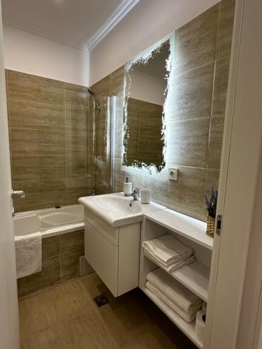 ein Badezimmer mit einem Waschbecken, einer Badewanne und einem Spiegel in der Unterkunft Luxury Studio 7 in Roşu
