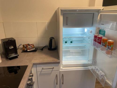 een lege koelkast met de deur open in een keuken bij Gemütliche und entspannte Stadtoase in Krefeld Zentrum, Deluxe Living, 50qm nähe Düsseldorf Messe, Netflix und IpTv in Krefeld