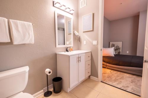 a bathroom with a sink and a toilet and a bed at DISNEY PARKS- International Dr - Orlando Luxury Condominium- Fully Equipped - 3bed & 2 bath- in Orlando