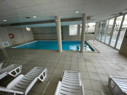 een zwembad met ligstoelen en een zwembad bij Appartement avec Sauna et Piscine au bord de mer in Plougonvelin