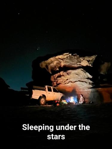 ein LKW, der vor einer Höhle mit einem Feuer parkt in der Unterkunft Bedouin experiences in Aqaba