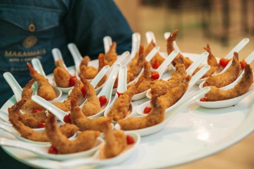 a plate of food with appetizers on plastic forks at Marambaia Hotel e Convenções in Balneário Camboriú