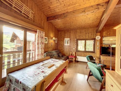 een kamer met een bed en een bank in een hut bij Appartement Combloux, 2 pièces, 6 personnes - FR-1-560-9 in Combloux