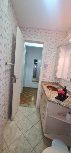 a bathroom with a sink and a toilet in a room at Centro Guarapari - espaço & conforto - WI-FI in Guarapari