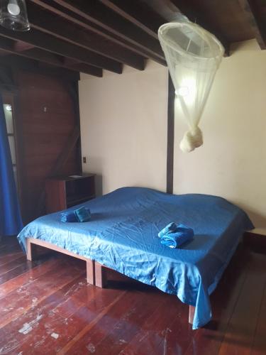 a bedroom with a bed with a blue comforter and a lamp at Charming Yellow Houses studio with patio in Bocas Town