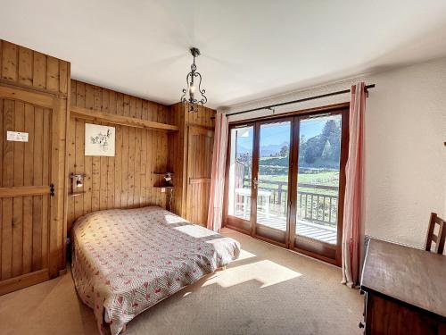 une chambre avec un lit et une grande fenêtre dans l'établissement Appartement 3 pièces de charme aux pieds des pistes à Combloux - FR-1-560-28, à Combloux