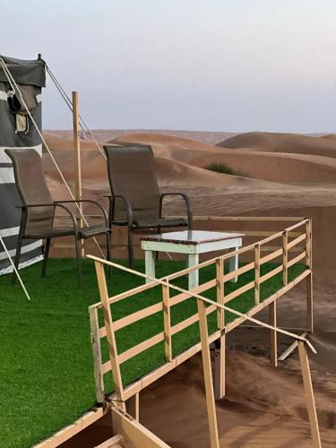 two chairs and a table in the middle of a desert at Sunrise Desert Local Private Camp in Bidiyah
