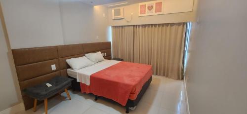 a bedroom with a bed with a red blanket at @ondinaapartreservas Pé na Areia 441 in Salvador