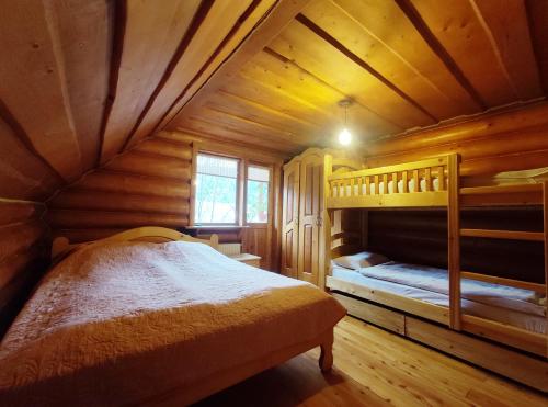 a bedroom in a log cabin with bunk beds at Дерев'яний котедж "Казка" in Yaremche