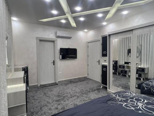 a bedroom with a bed and a television in it at Asia Hotel Apartments in Irbid