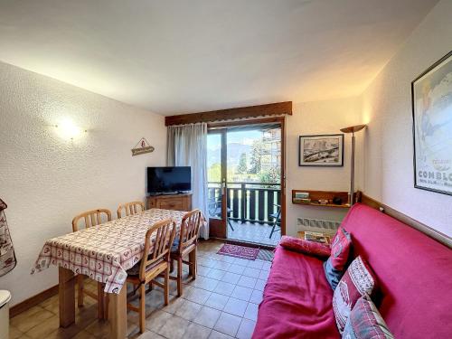 un salon avec une table et un canapé rouge dans l'établissement Studio cabine proche centre Combloux, 4 pers, balcon, parking - FR-1-560-53, à Combloux
