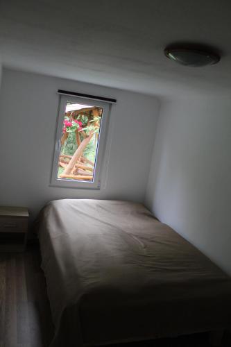 a small bedroom with a bed and a window at Csergő Kulcsosház in Senetea