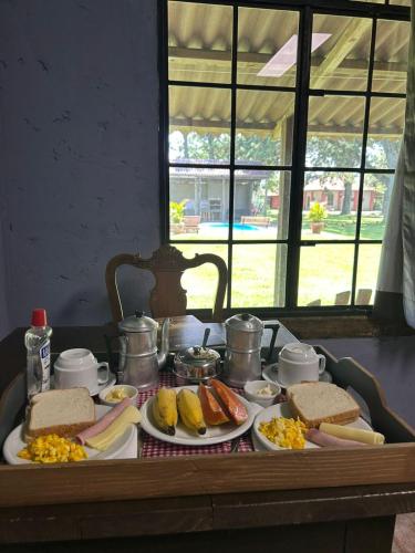 a table with plates of food on top of it at Pousada Charqueada Costa do Abolengo in Pelotas