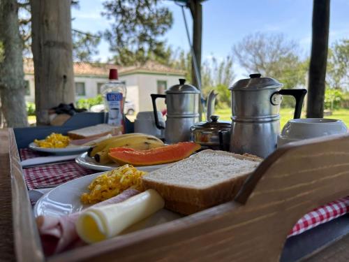a picnic table with bread and other food on it at Pousada Charqueada Costa do Abolengo in Pelotas