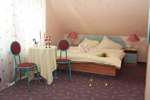 金日瓦特礦泉鎮的住宿－Penzion Hubertus，一间卧室配有一张带桌子和两把椅子的床