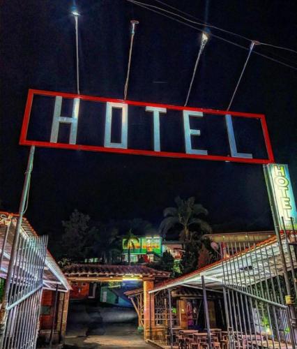 a lit up sign for a hotel at night at Hotel La Isla in San Gil