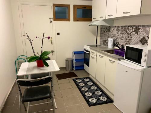 une petite cuisine avec une table et un micro-ondes dans l'établissement Appartement cosy à Montmorency avec terrasse | 36 m², à Montmorency