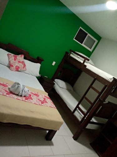 a bedroom with two bunk beds and a green wall at Hotel La Isla in San Gil