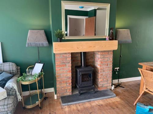 a living room with a brick fireplace with a mirror at Tenby 2 bed flat with parking, plus pet in Tenby