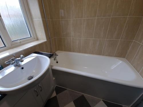 Walker Lodge في أولدبيري: حمام مع حوض أبيض ومغسلة