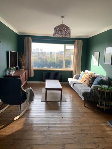 a living room with a couch and a table at Tenby 2 bed flat with parking, plus pet in Tenby