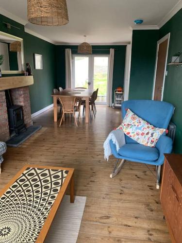 a living room with a blue chair and a table at Tenby 2 bed flat with parking, plus pet in Tenby