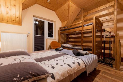 2 letti a castello in una camera con soffitti in legno di Domki Nad Zatoką a Kluszkowce