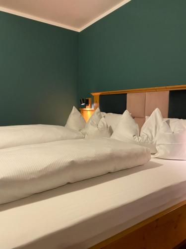 2 łóżka w pokoju z zieloną ścianą w obiekcie Beim Has’n w mieście Rimsting