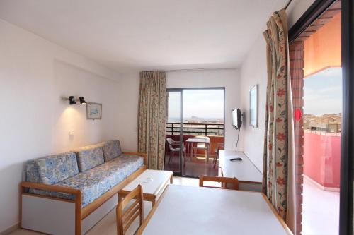 ein Wohnzimmer mit einem Sofa und einem Tisch in der Unterkunft Apartamentos La Caseta - SABESA in Benidorm