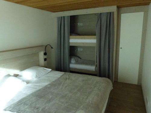 1 dormitorio con cama y ventana con escalera en Appartement Le Grand-Bornand, 2 pièces, 6 personnes - FR-1-467-96, en Le Grand-Bornand