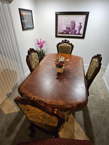 una mesa de madera en una habitación con sillas alrededor en Lofty Haven, your home away from home!, en Huntsville