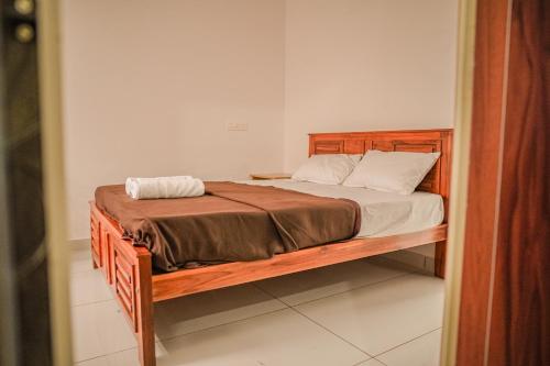 a bed with a wooden frame in a room at Shimano Square in Varkala
