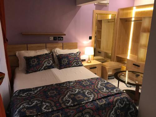 een slaapkamer met een bed en een tafel met een lamp bij S.K PLAZA in Oost-Legon