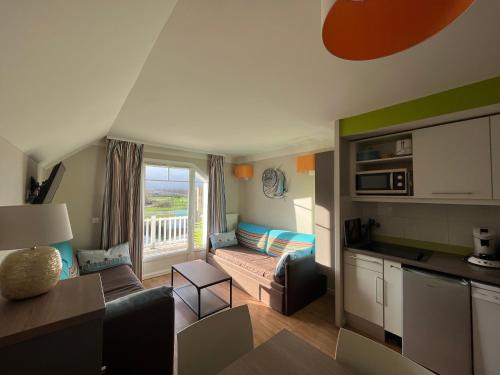 une cuisine et un salon avec un canapé et une table dans l'établissement Entre Seulles & Mer proche port de Plaisance, à Courseulles-sur-Mer