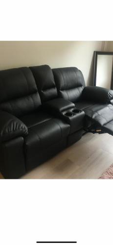 a black leather couch sitting in a living room at Oslo new center in Oslo