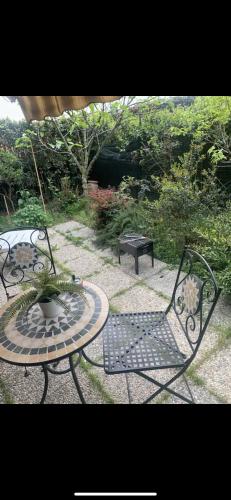 um pátio com 2 cadeiras, uma mesa e um banco em Grazioso monolocale con giardino em Pregnana Milanese