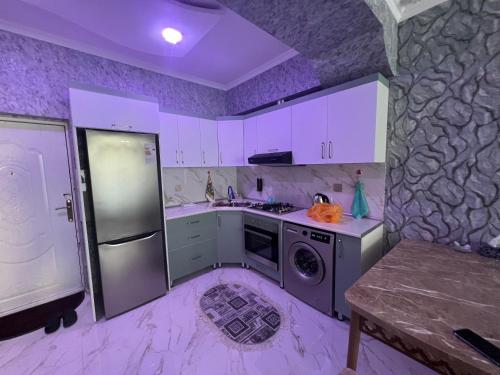 eine Küche mit weißen Schränken und einer Waschmaschine in der Unterkunft Astara Park White House in Astara