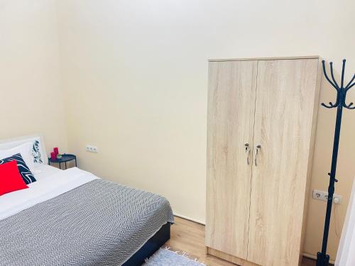 a bedroom with a bed and a wooden cabinet at Like Home Rooms in Almaty